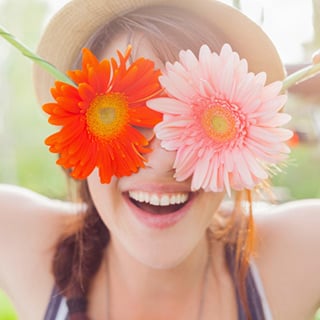 young-woman-holding-flowers-over-her-eyes_web