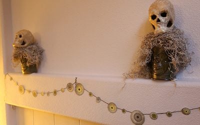 DIY Halloween Mantel With Eyeball Garland and Decoupaged Glow-in-the-Dark Skull Stantions